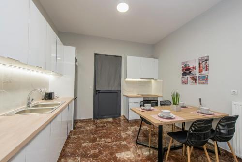 a kitchen with a table and chairs and a sink at Bright & Stunning Flat in the City Centre in Zakynthos Town