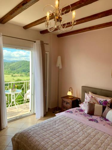 a bedroom with a bed and a view of a balcony at Ermones Diamond Villa in Vátos