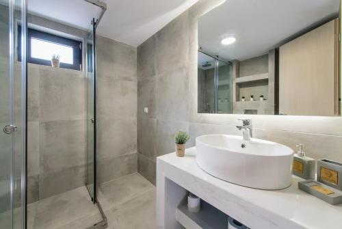 uma casa de banho com um lavatório e um chuveiro em Bright & Stunning Flat in the City Centre em Zakynthos