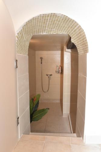 La salle de bains est pourvue d'une douche et d'un mur en carrelage. dans l'établissement Casa Mia, à Antibes