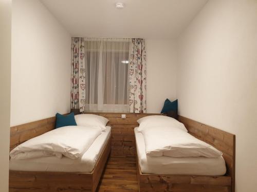 2 Betten in einem Zimmer mit Fenster in der Unterkunft Ferienwohnung Alter Farbhof in Ühlingen-Birkendorf