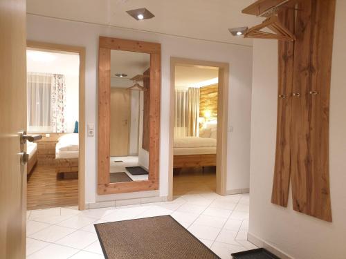 ein Zimmer mit einem Spiegel und ein Schlafzimmer mit einem Bett in der Unterkunft Ferienwohnung Alter Farbhof in Ühlingen-Birkendorf