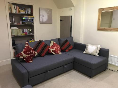 a blue couch with pillows in a living room at Red Dragon Cottages nr Mt Snowdon in Beddgelert