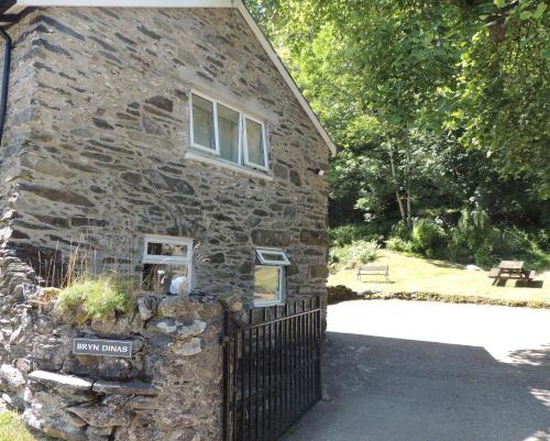 an old stone house with a sign in front of it at Red Dragon Cottages nr Mt Snowdon in Beddgelert