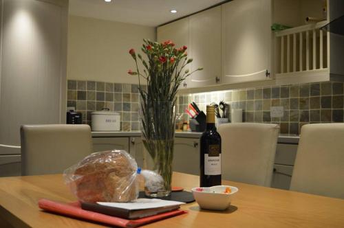 a bottle of wine on a table in a kitchen at Red Dragon Cottages nr Mt Snowdon in Beddgelert