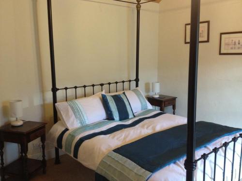 a bedroom with a four poster bed with two tables at Red Dragon Cottages nr Mt Snowdon in Beddgelert