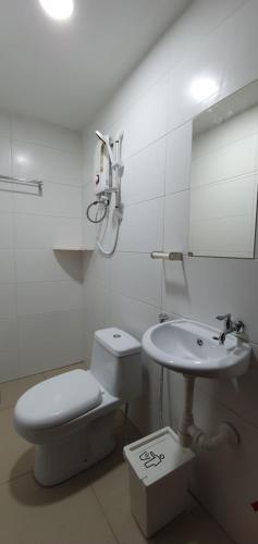 La salle de bains blanche est pourvue de toilettes et d'un lavabo. dans l'établissement Thian Siong Inn, à Malacca