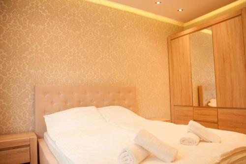 1 dormitorio con cama blanca y espejo en Apartament Turoszowska en Lodz