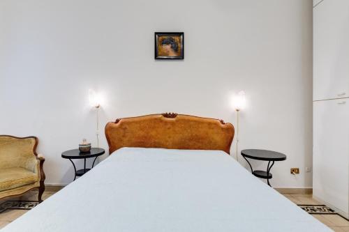 een slaapkamer met een bed en 2 tafels en een stoel bij Appartamento con 3 camere da letto e 2 bagni vicino al Vaticano in Rome