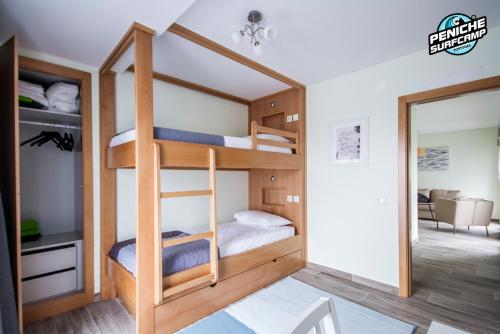 a bedroom with bunk beds and a living room at Ocean Two & Three Room Apartments in Peniche