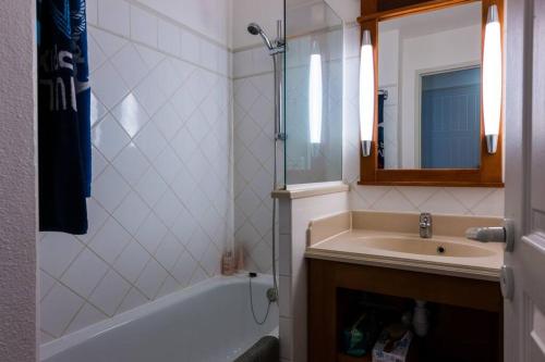 une salle de bain avec une baignoire, un lavabo et un miroir dans l'établissement Lumineux, vue piscine, face au Golf, Lacanau Ocean, à Lacanau