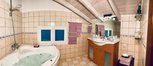 a bathroom with a tub and a sink at Ermones Diamond Villa in Vátos