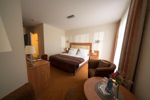 a hotel room with a bed and a chair at Hotel & Café Strandeck in Prerow