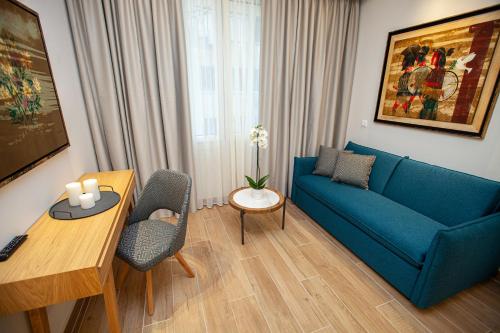 a living room with a blue couch and a table at No21 Luxury Suites in Thessaloniki