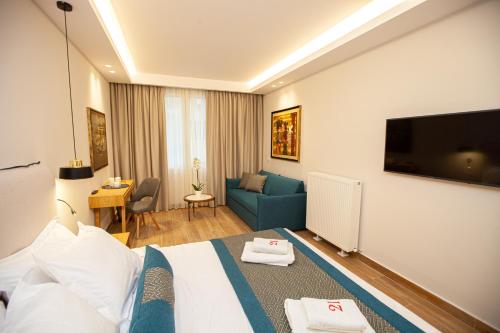 a hotel room with a bed and a tv at No21 Luxury Suites in Thessaloniki