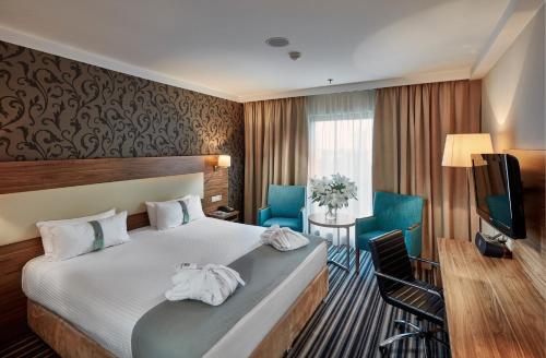 a hotel room with a bed and a television at Holiday Inn Łódź by IHG in Łódź