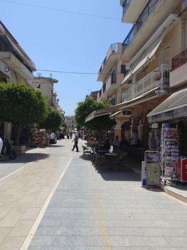 a person walking down a street next to buildings at Bright & Stunning Flat in the City Centre in Zakynthos Town
