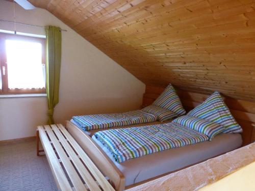 eine Bank mit zwei Kissen in einem Zimmer in der Unterkunft Haus Schloßwiese in Bad Füssing