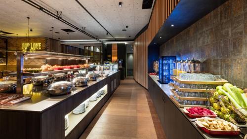 a restaurant with a buffet line with food at Holiday Inn Perth City Centre by IHG in Perth