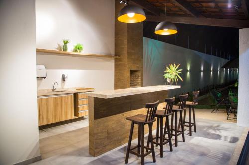 a kitchen with a bar with stools around it at Juazeiro Comfort Hotel in Juazeiro do Norte