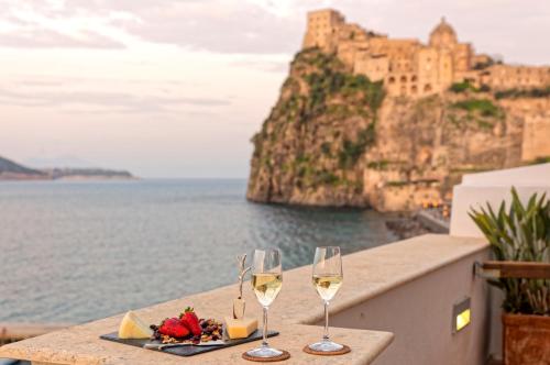two glasses of wine on a table with a view of the ocean at Villa Lieta in Ischia