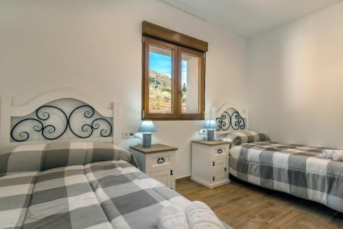 a bedroom with two beds and a window at Alpujarra Arena in Soportújar