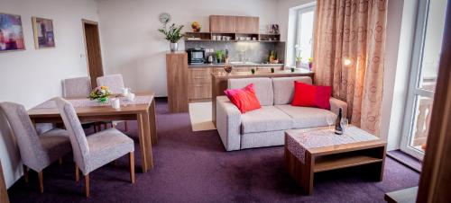 a living room with a couch and a table at Apartmanový Dom TatraTravel Smokovec in Vysoké Tatry