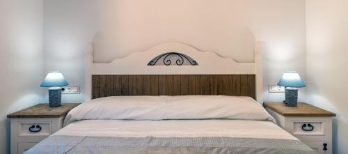 a bedroom with a bed with two lamps on tables at Alpujarra Arena in Soportújar