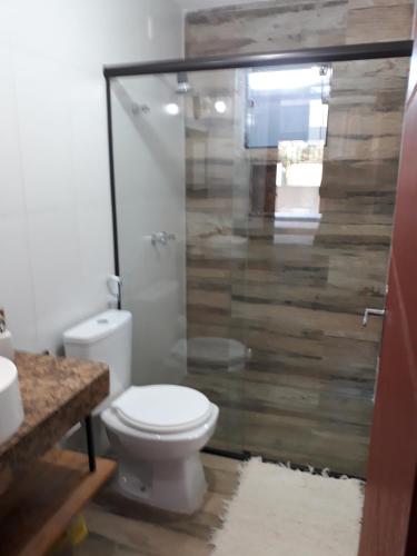 a bathroom with a toilet and a glass shower at DaMa 1 in Tiradentes