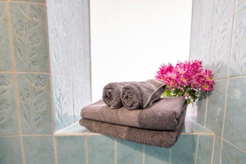a towel rack with towels and flowers in a bathroom at Radazul Marina Seafront 12 in Radazul
