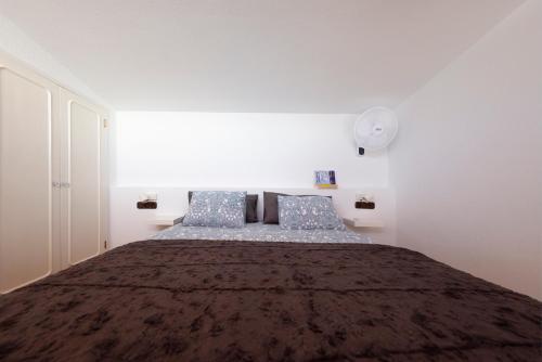 a bedroom with a large bed with blue pillows at Radazul Marina Seafront 12 in Radazul