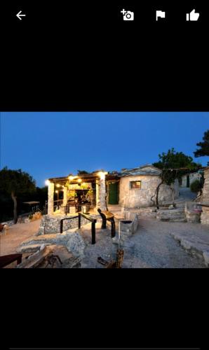 a stone building with lights on in front of it at Apartmani "Mary" in Grebaštica