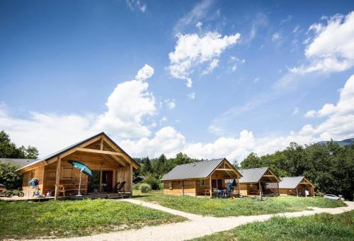 a group of wooden cabins in a field at Huttopia Lac d'Aiguebelette in Saint-Alban-de-Montbel