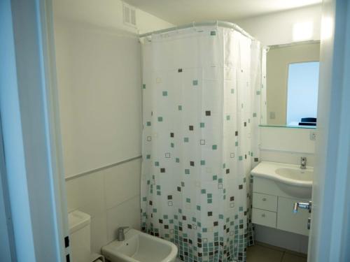 y baño con aseo, lavabo y ducha. en SMA FLATS en Neuquén