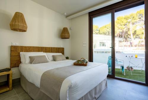 sypialnia z dużym łóżkiem i dużym oknem w obiekcie Alidreams Carmen Beach Apartamentos w mieście El Campello