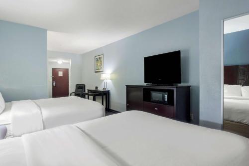 a hotel room with two beds and a flat screen tv at Motel 6-Mineral Wells, TX in Mineral Wells