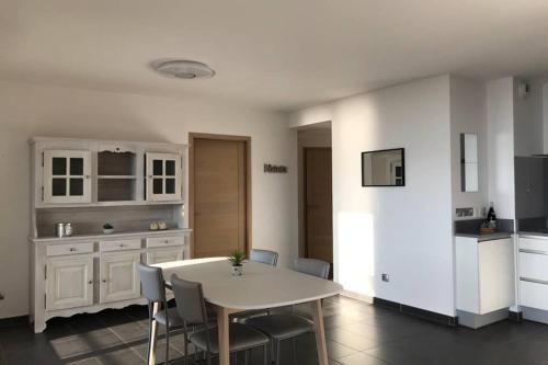 une cuisine avec une table et des chaises dans une pièce dans l'établissement ROC & LAC - Terrasse vue lac, piscine, parking, à Veyrier-du-Lac