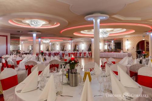 a banquet hall with white tables and red chairs at Dworek Góralski in Łodygowice