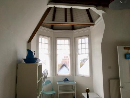 Cette chambre comprend une fenêtre, une table et des chaises. dans l'établissement Lyme Regis renovated period seaside flat, à Lyme Regis