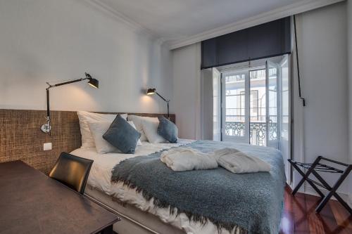 um quarto com uma cama com duas almofadas em Nomad's Fine Arts in Chiado with Garage em Lisboa