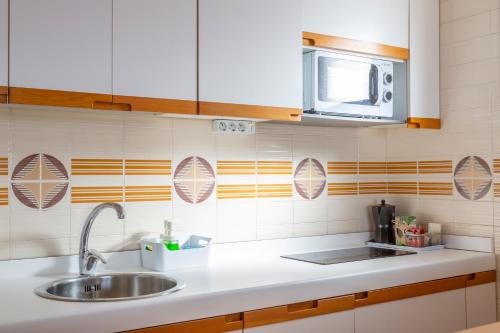 a kitchen with a sink and a microwave at Radazul Marina Seafront 13 in Radazul