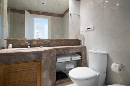 een badkamer met een wastafel, een toilet en een spiegel bij Nomad's Fine Arts in Chiado with Garage in Lissabon