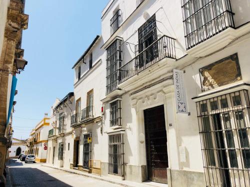 a white building with balconies on a city street at Art Suites by Casa de Indias in El Puerto de Santa María
