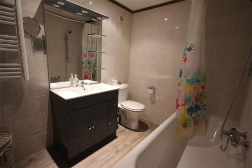 une salle de bain avec un lavabo, une baignoire et des toilettes dans l'établissement Domaine de vacances à 600m de la plage villa 3 chambres climatisées 7 couchages WIFI terrasse parking animations et piscines en supplément LRPDSR8, à Portiragnes