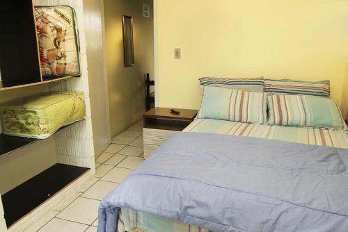 a small bedroom with a bed and a night stand at Hotel Paulista in Barra Velha