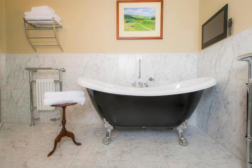 a bathroom with a large tub and a stool at Coul House Hotel in Contin
