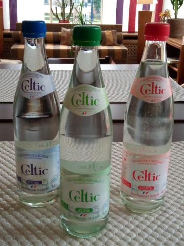 three bottles of water sitting on a table at Hôtel Restaurant Le Bristol in Niederbronn-les-Bains