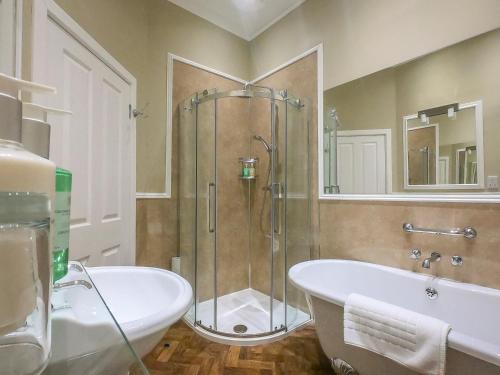 a bathroom with a shower and a tub and a sink at Coul House Hotel in Contin