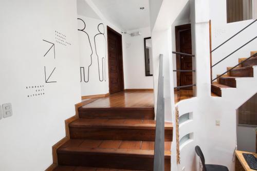 a staircase in a home with white walls and wooden floors at AlterNative Hostels in Cuenca