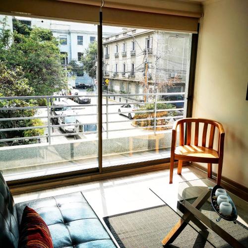 a living room with a couch and a large window at Apart Hotel Viva Providencia in Santiago
